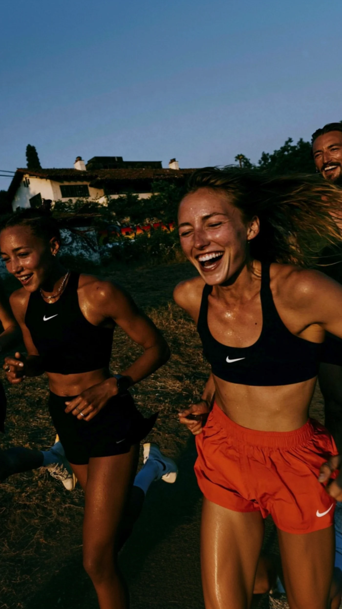 Trois coureurs qui rient, au coucher du soleil